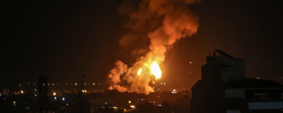 Fires erupt from a building following an airstrike. Photo credit: Shutterstock.