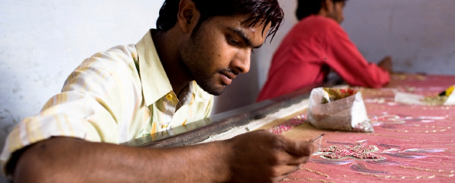 Male homeworker, hand-embelishing fabric, India