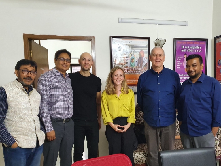 Florence Batten-Turner stands smiling with colleagues at the ETI Bangladesh office. Photo credit: Florence Batten-Turner.