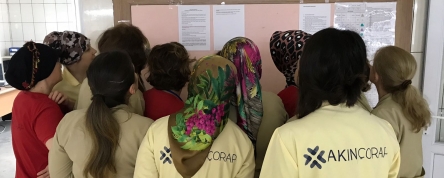 Akin Socks' workers reading the factory's written confirmation of the right to organise.