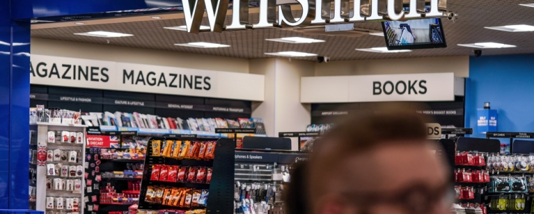 London, United Kingdom - February 05, 2019: Unknown man walks in front of WHSmith branch at London Luton airport. WHS is major British retailer selling mostly books, stationery, magazines & newspapers. Photo credit: Lubo Ivanko, Shutterstock.