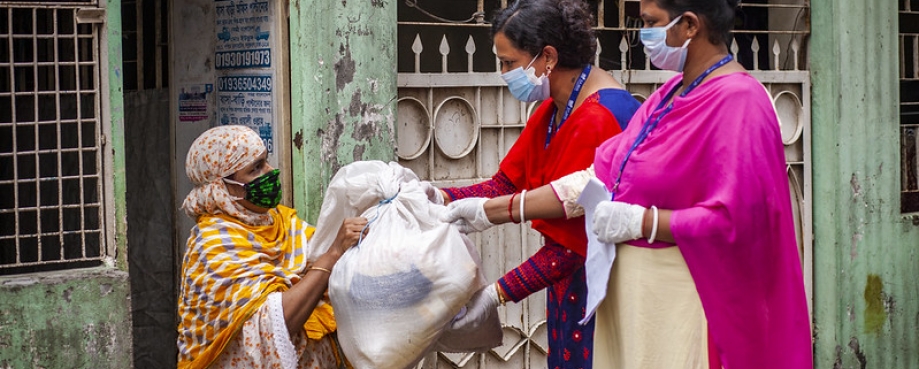 Development workers hand over relief aid to a woman amid the Covid-19 pandemic at Madartek area in Bashabo of Dhaka. Photo credit: UN Women/Fahad Abdullah Kaizer.