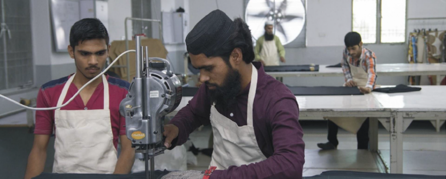 Two garment workers operating a sewing machine. Photo credit: The Parently Group.