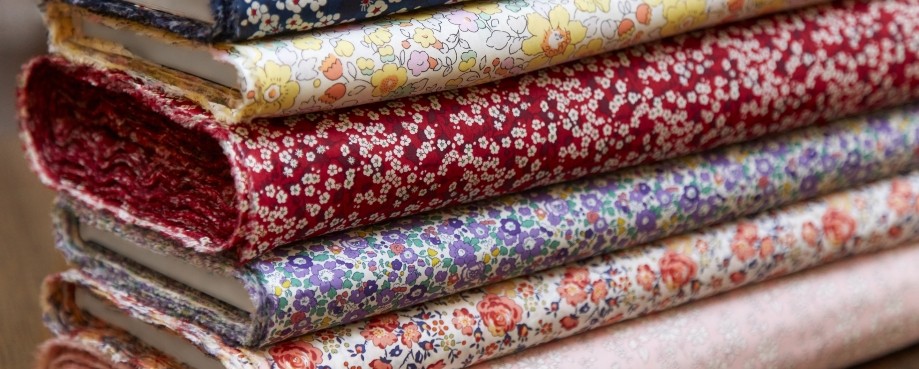 A pile of folded Liberty fabrics. Photo credit: Liberty.