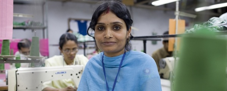 Female garment worker on a factory sewing floor, India