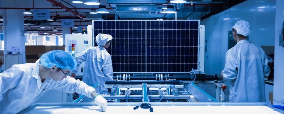 Factory workers lifting new solar panel from production line,and the technician is checking it in the factory, China. Photo credit: Shutterstock.