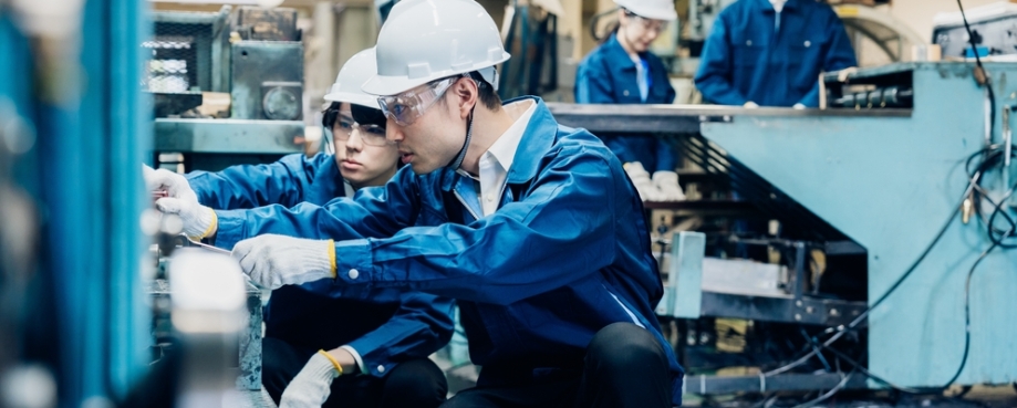 Factory workers in Korea, servicing machinery