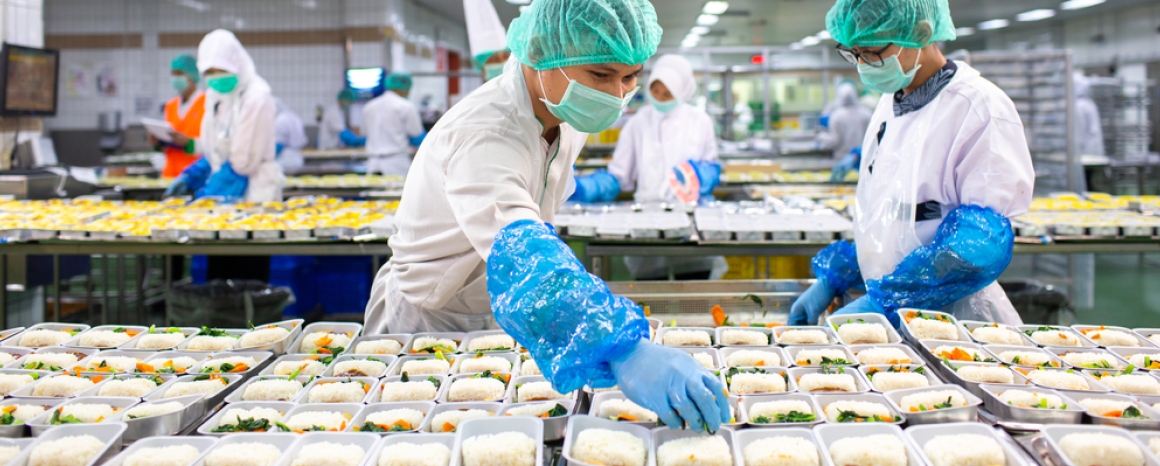 Two workers prepare food for airline meals, in Indonsia