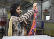 Female garment worker, checking a garment, India