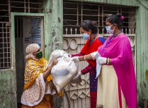 Development workers hand over relief aid to a woman amid the Covid-19 pandemic at Madartek area in Bashabo of Dhaka. Photo credit: UN Women/Fahad Abdullah Kaizer.
