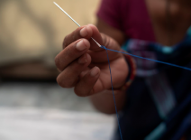 Garment worker holding a needle and thread