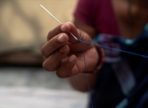 Close-up of needle and thread in the hand of a homeworker