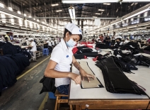 Vietnamese garment worker pinning trousers © ILO Aaron Santos