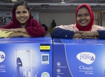 Female overseas workers receive water filters from ONE+ALL.