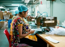 A woman using industrial equipment inside packaging manufacturing plant in India. Photocredit: Shutterstock.