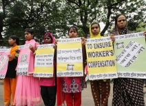 Young women workers hold up signs demanding compensation following the collapse of Rana plaza. Photo credit: Shutterstock/ Bayazid Akter.