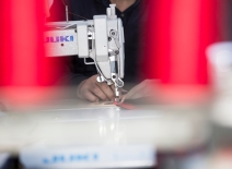 A persons hands working at a sewing machine. Photo credit: Shutterstock.