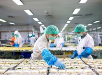 Two workers prepare food for airline meals, in Indonsia
