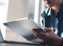 A woman using digital tablet and laptop computer to work from home. Photo credit: Shutterstock.