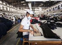 Woman pinning trousers in Vietnamese factory ©ILO/Aaron Santos